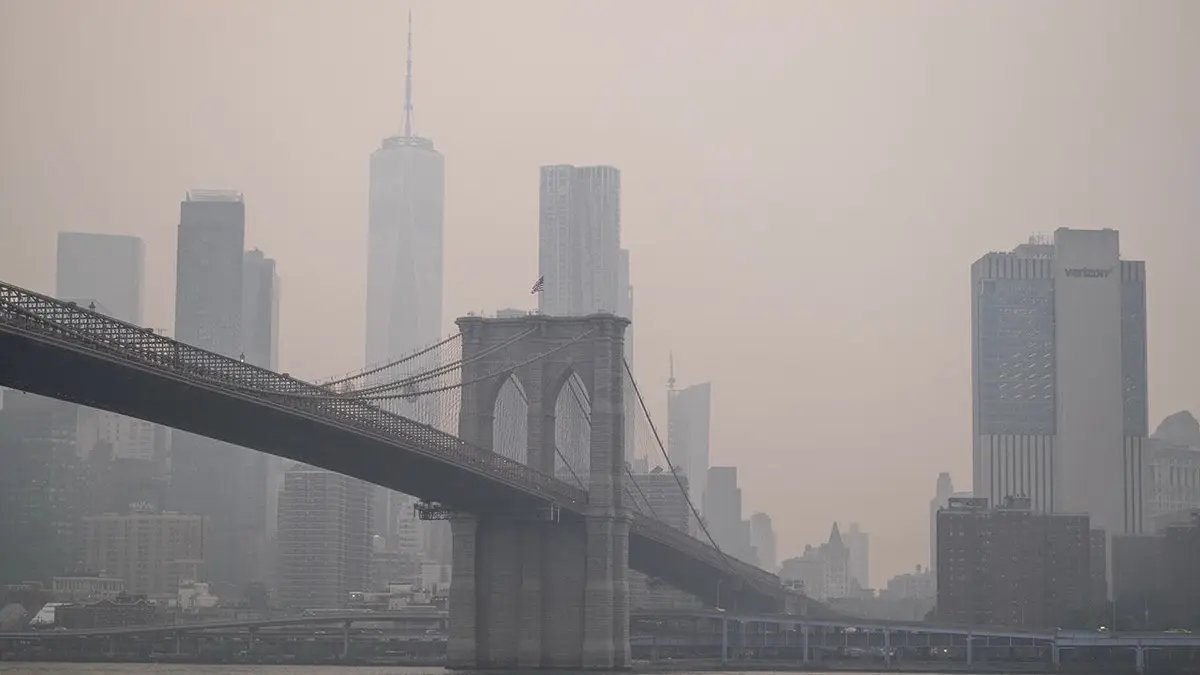 Trump Threatens Tariffs on Canada Over Wildfire Smoke, Sparking Bilateral Clash Over Forest Management 3 Smoke shrouds the Manhattan skyline over Brooklyn.