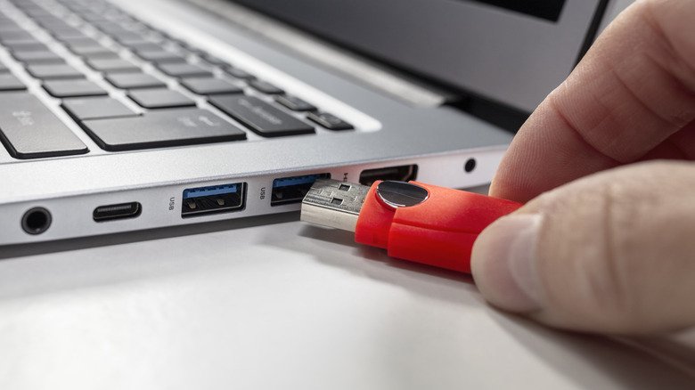A USB drive being plugged into a laptop
