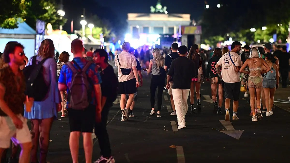 Fatal Vehicle Incident at Berlin Pride Parade Prompts Mass Manhunt and Event Cancellation 2 People stand on 17 June Street in Berlin following Christopher Street Day cancellation.