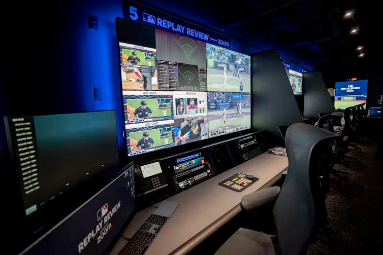 a dark room with several large video displays showing multiple images