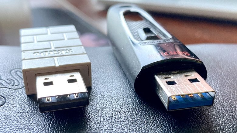 A USB 2.0 wireless gamepad dongle next to a USB 3.0 USB flash drive