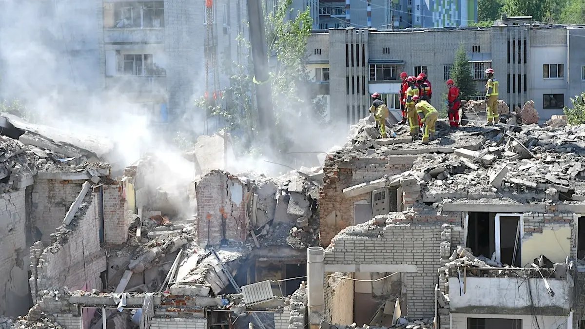 Russian Missile Crash in Poland Escalates Regional Alarm as Air Strikes Devastate Ukraine 2 Emergency workers clear rubble with heavy equipment in Lviv, Ukraine.