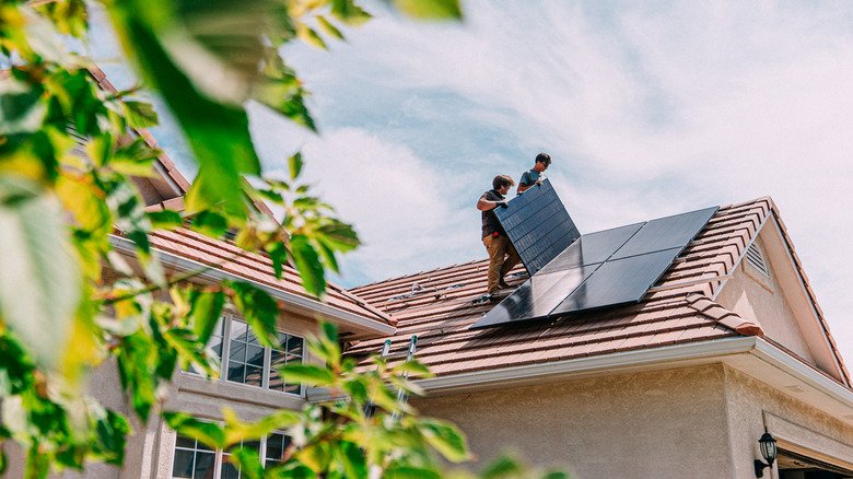 Why Solar Installers Recommend the 20 Percent Oversizing Rule for Home Systems 3 Fitters installing solar panels onto the roof of a home