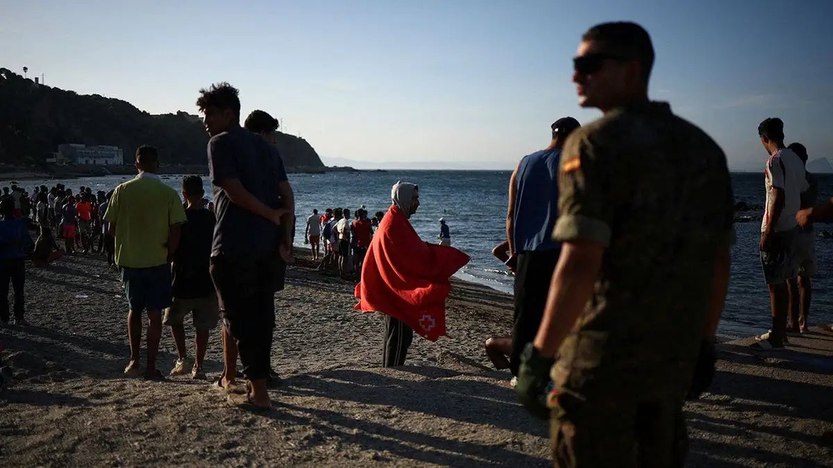 Migrants wait outside Ceuta's temporary migrant center