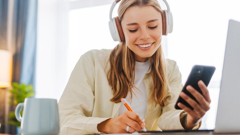 How Bluetooth Multipoint Is Reshaping Multi-Device Audio Connections 2 Woman wearing headphones while using phone and laptop