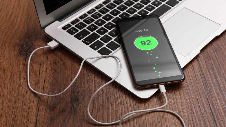 Why Using Your Phone While Charging Won't Ruin Its Battery — The Science of Power Management 3 A phone plugged into a laptop, charging.