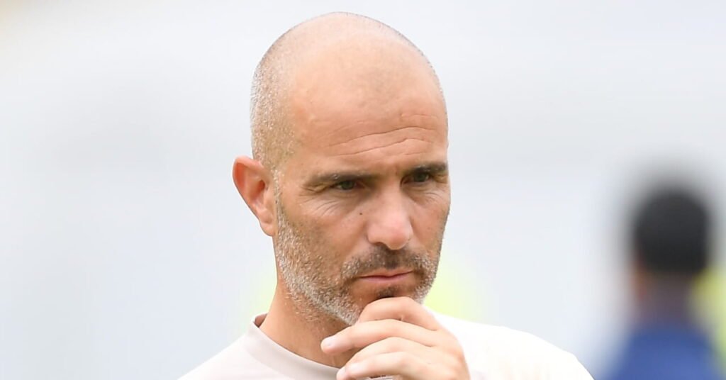 Arsenal Favored to Retain Premier League Title as Rivals Face Managerial Overhauls 3 Football manager Enzo Maresca holding his chin during a training session held by the head coach while he wears a light-coloured top
