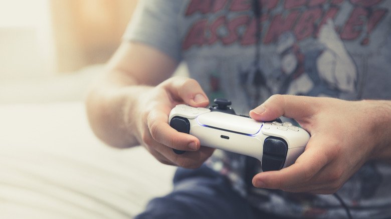 A player's hands holding a PS5 controller