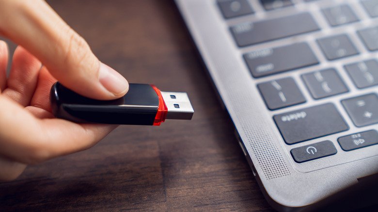 Cross-Platform Mobility vs Data Protection: How exFAT and NTFS Define Storage Standards 2 Woman inserting thumb drive into laptop port
