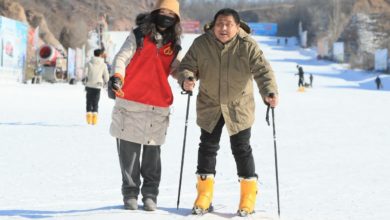 A person with disabilities learns to ski with the help of a volunteer in Chaoyang city, northeast China’s Liaoning province, Jan. 20, 2022. (Photo by Qiu Yijun/People’s Daily Online)