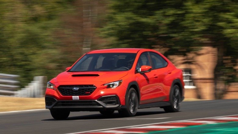 سوبارو WRX 2026.. أداء رياضي يدوي بسعر يبدأ من 1.7 مليون جنيه 7 A front three-quarters shot of a red WRX driving on Oulton Park past trees