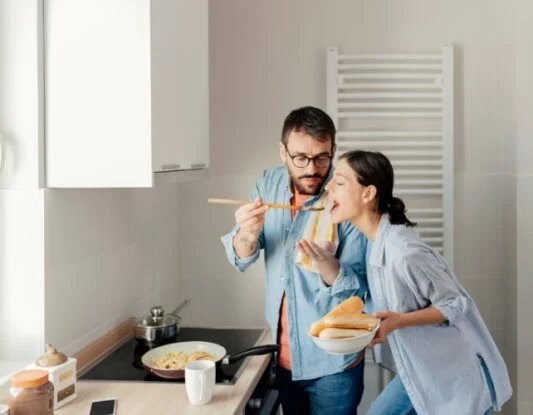 هرمون الحب ليس للمشاعر فقط.. خلايا في الدماغ تكشف دوره في التغلب على الخوف 2 A young couple cooking dinner and tasting food on a spoon
