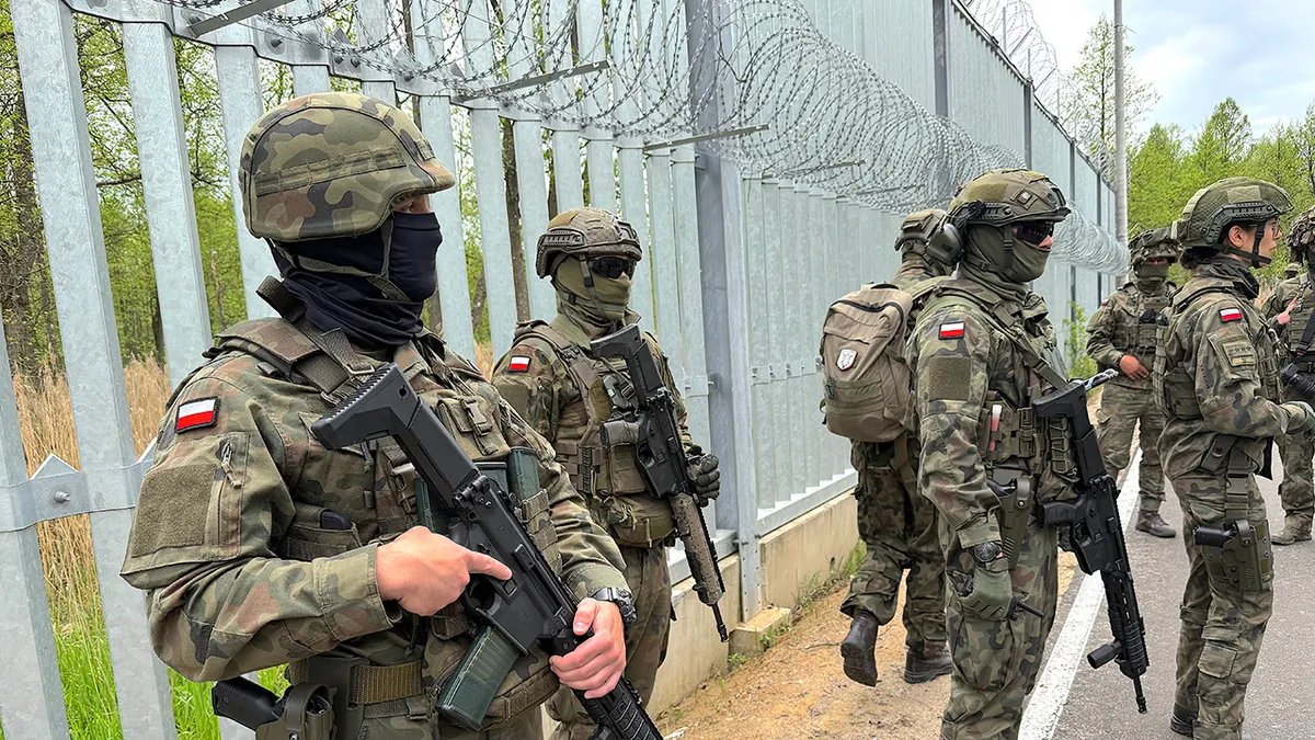 Polish soldiers stand guard at the border with Belarus.