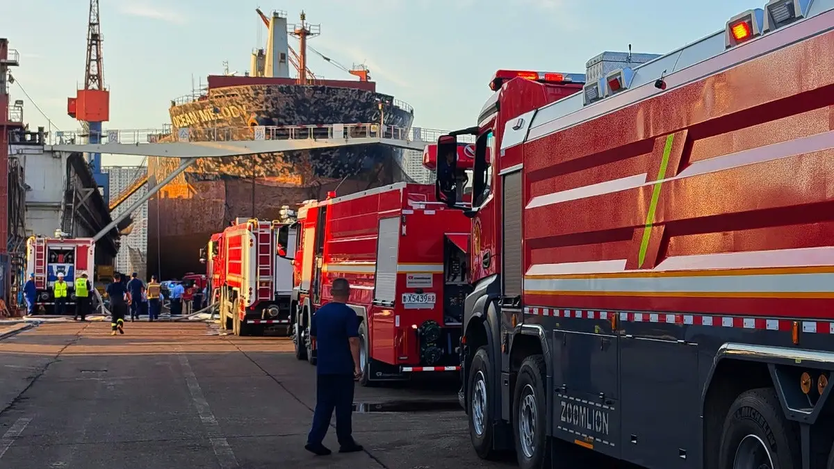 Firefighters and crews gather near the cargo ship