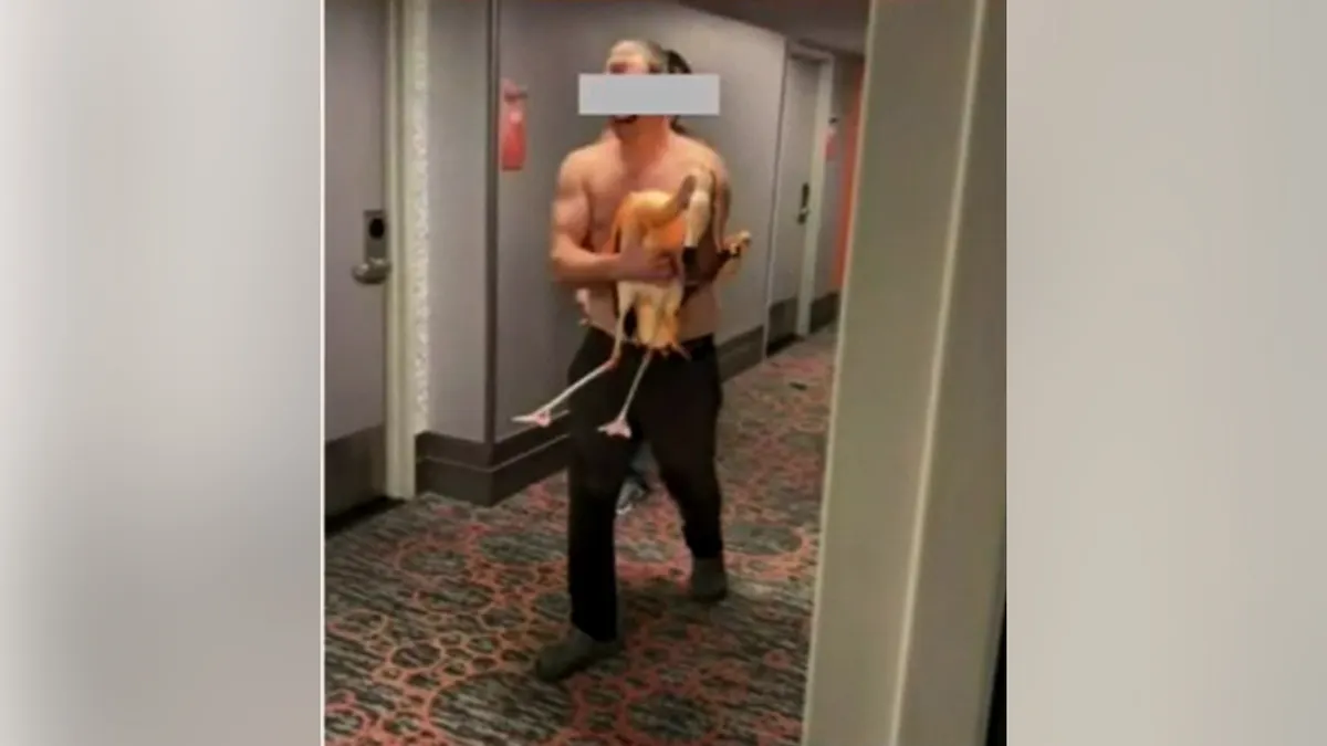 A man holding a flamingo in a hallway