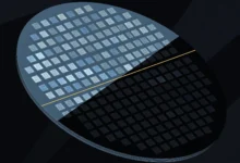 Abstract illustration of a silicon wafer, half in light and half in shadow, divided by a thin gold line.