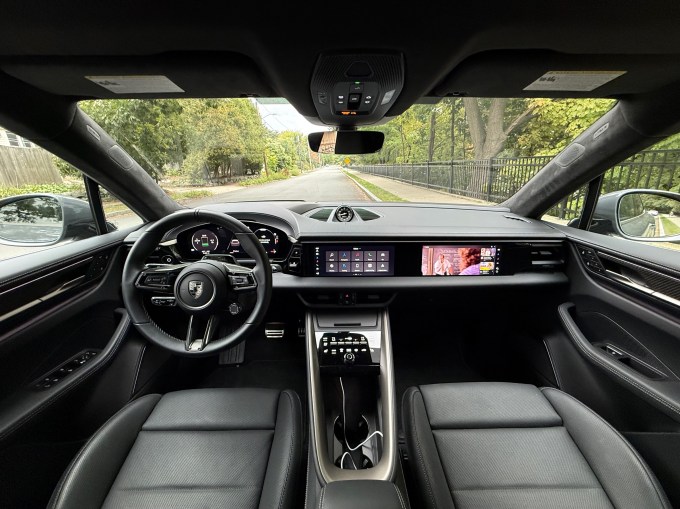 Three screens illuminate the dash of a Macan EV.