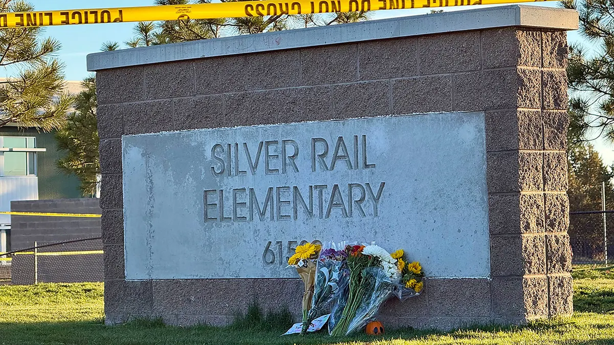 Flowers are placed beside a sign at Silver Rail Elementary School in Bend, Ore., on Friday, Oct. 16, 2026, a day after a deadly shooting.