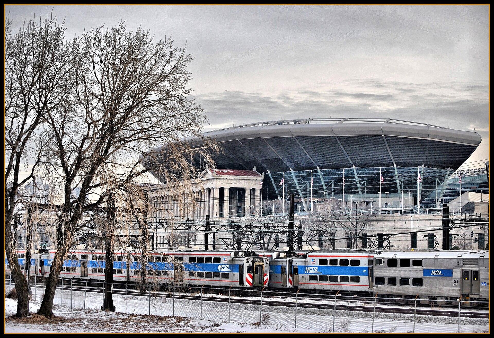 Soldier Field's colonnades and bowl behind a Metra train in winter